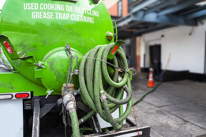 a technician pumping a grease trap in a commercial building in Llano